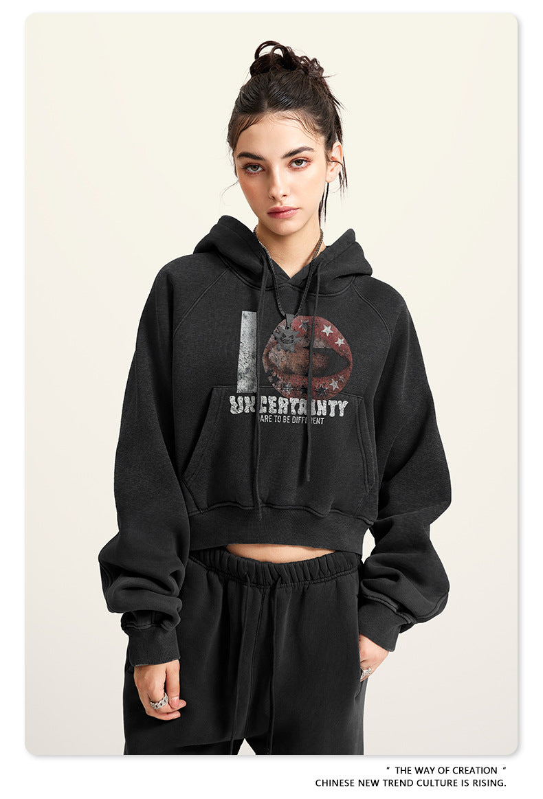 Black cropped hoodie with graphic print, model front view