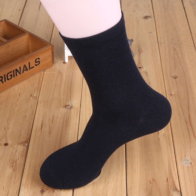 Navy blue cotton crew sock displayed on white mannequin leg against wooden background