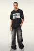 Male model wearing black "New Adventures Ahead" t-shirt with distressed graphic and ripped gray jeans