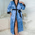 Blue satin robe with heart and "love" print, black trim, worn by woman in bedroom setting