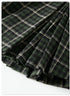 Close-up of green plaid fabric folds showing texture and pattern detail against dark background