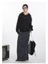 Oversized black hoodie featuring eye logo and metal snap details, styled with charcoal maxi skirt and black leather tote bag