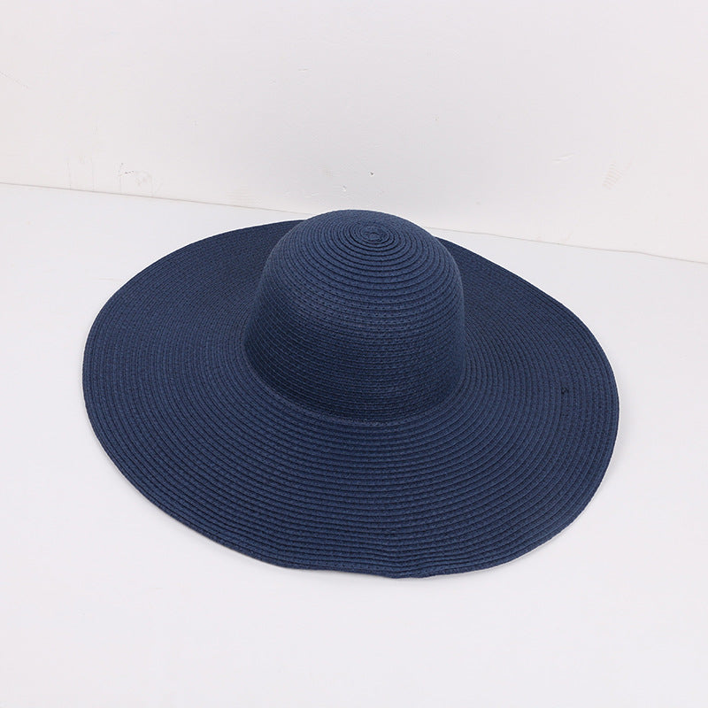 Navy blue wide-brimmed sun hat with a woven texture, placed on a white background.