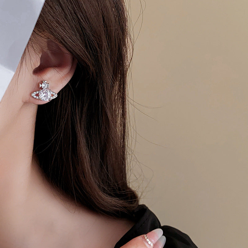 Close-up of designer celestial earring with long white nail