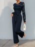 Side angle of the navy blue lace jumpsuit, showcasing the sleek fit and belted waist.