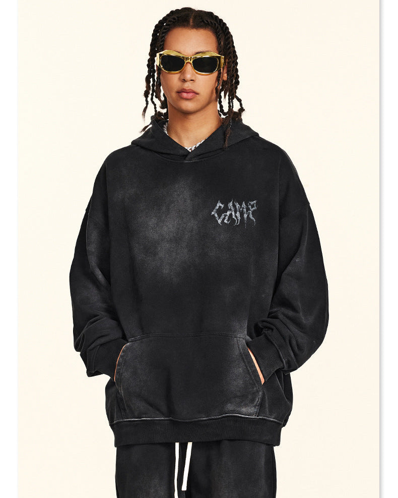 Back view of person with braided hair in black washed hoodie featuring metal-style logo and checklist text