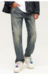 Close-up of relaxed fit vintage wash jeans with classic 5-pocket styling and white platform sneakers