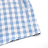 Hem detail of the blue gingham top, focusing on the clean stitching and lightweight fabric.