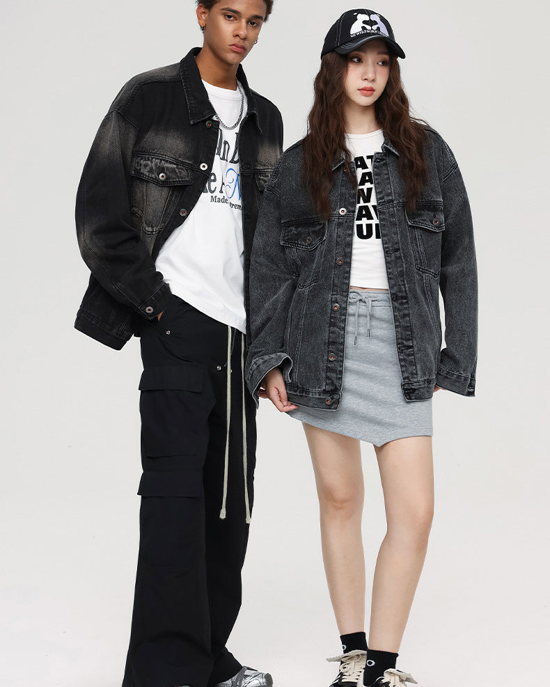 A male model in a gradient black denim jacket and cargo pants stands beside a female model in an oversized denim jacket, a mini skirt, and a graphic cap