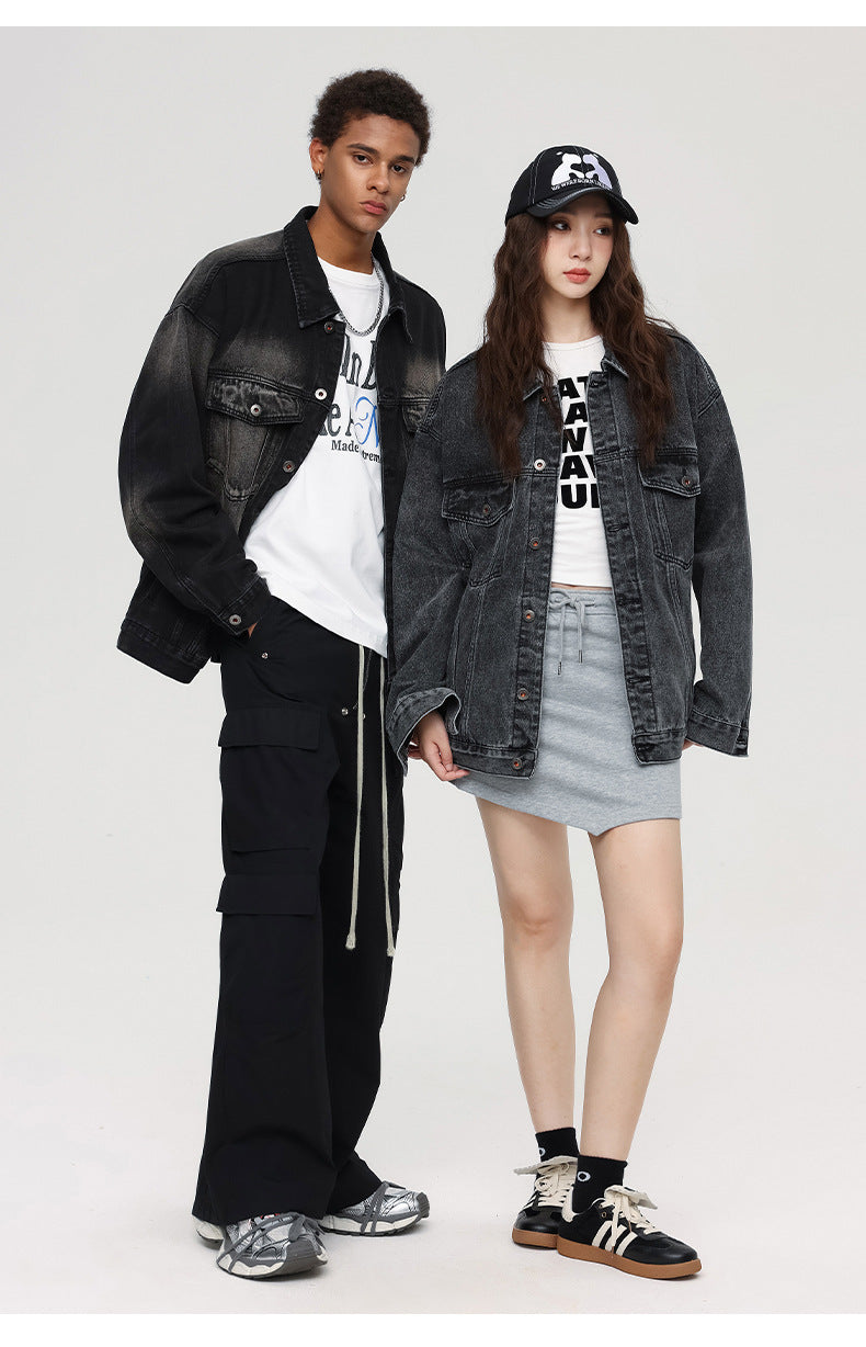 A male model in a gradient black denim jacket and cargo pants stands beside a female model in an oversized denim jacket, a mini skirt, and a graphic cap