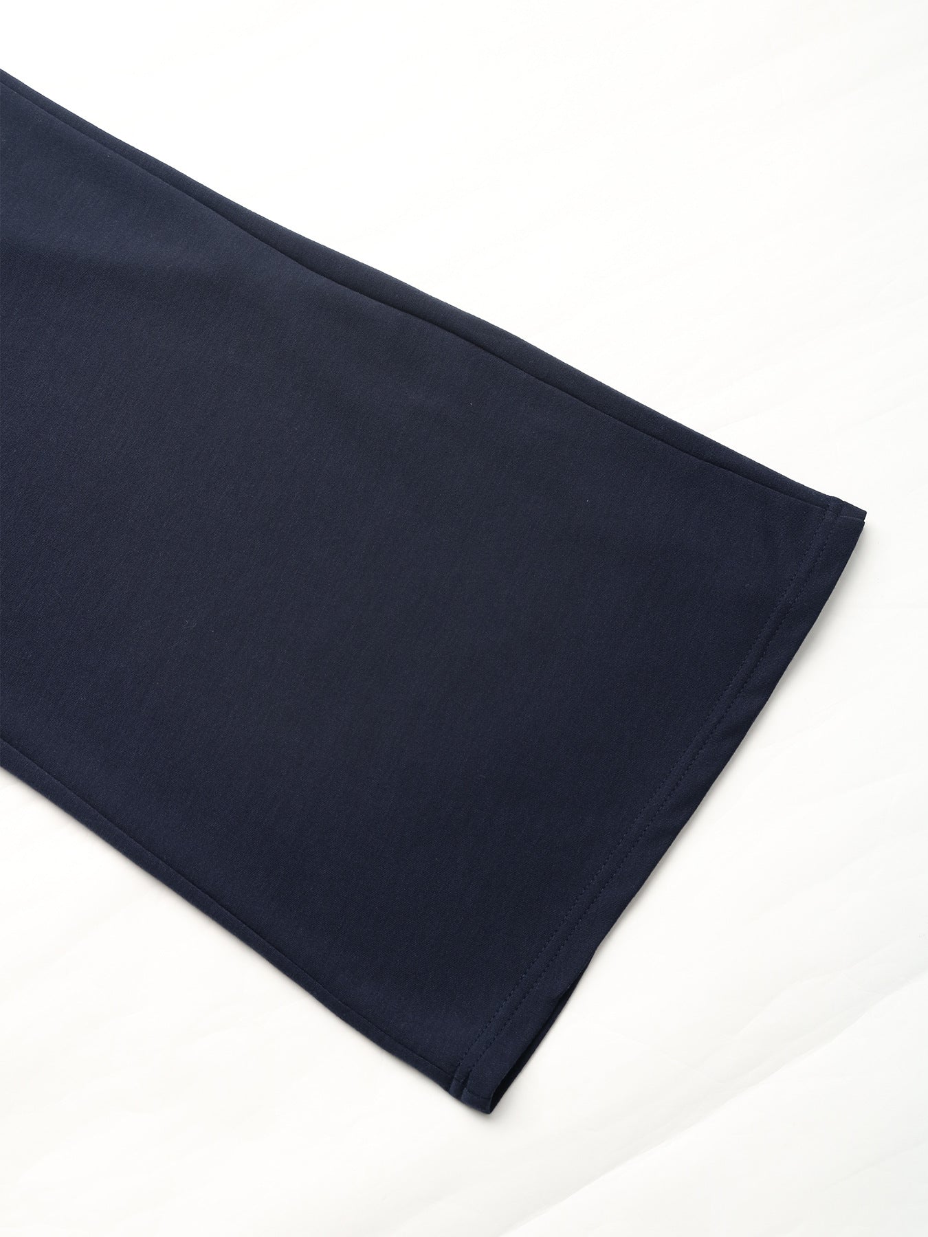 Hem detail of navy blue wide-leg pants, showing the clean stitch finish and wide-leg cut.