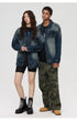 Full-length shot of models in denim jackets, one wearing cycling shorts and combat boots, other in camo pants