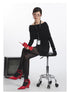 Black off-shoulder sweater with layered folded collar and long sleeves. Side angle with ID badge detail.