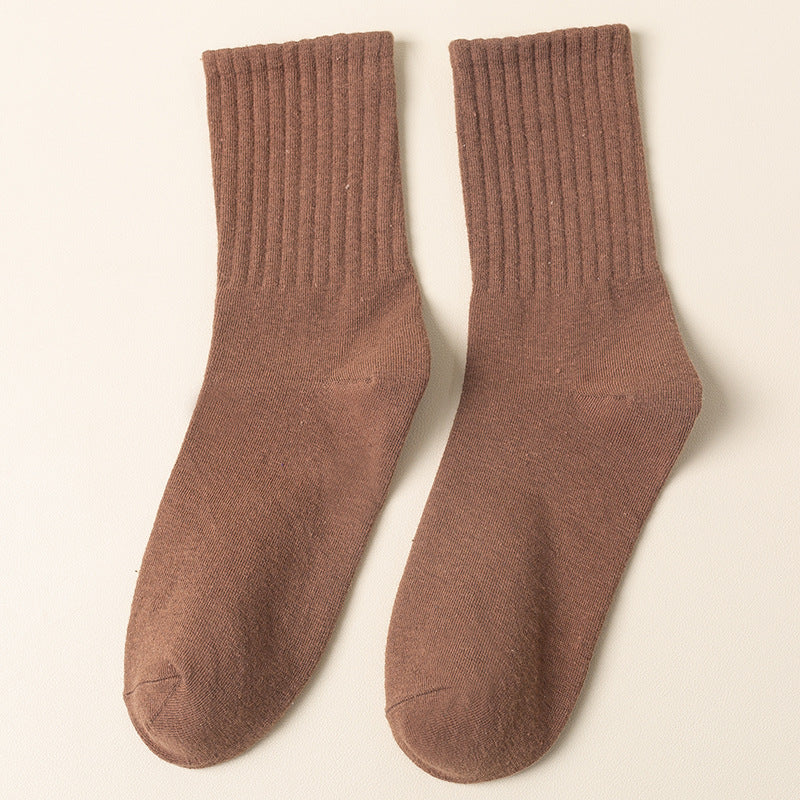 A pair of brown ribbed crew socks displayed flat against cream background showing texture and full length