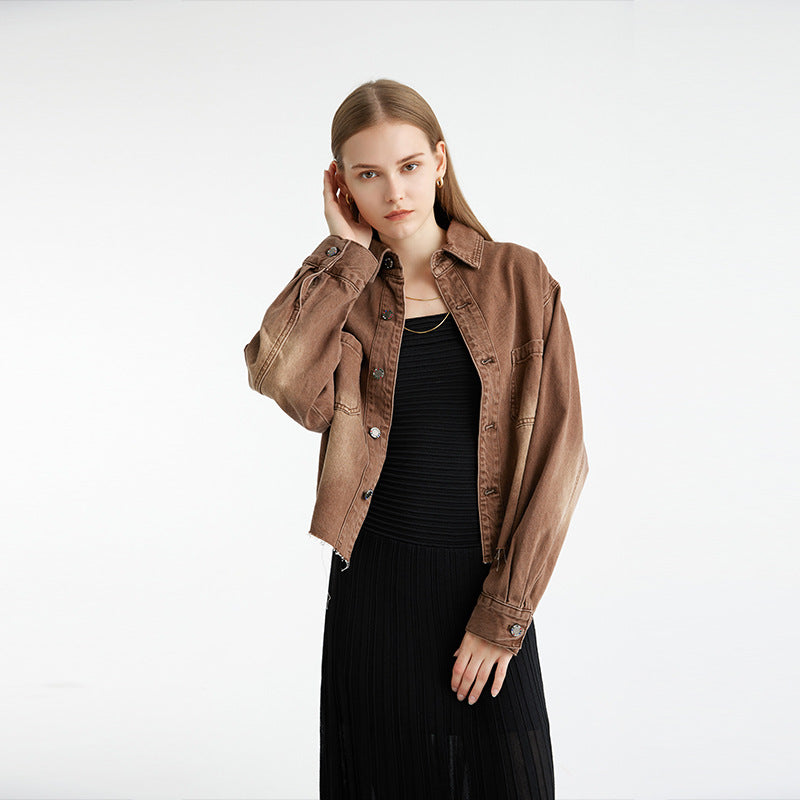 Vintage-inspired brown denim jacket, model posing with hand near face, black long dress