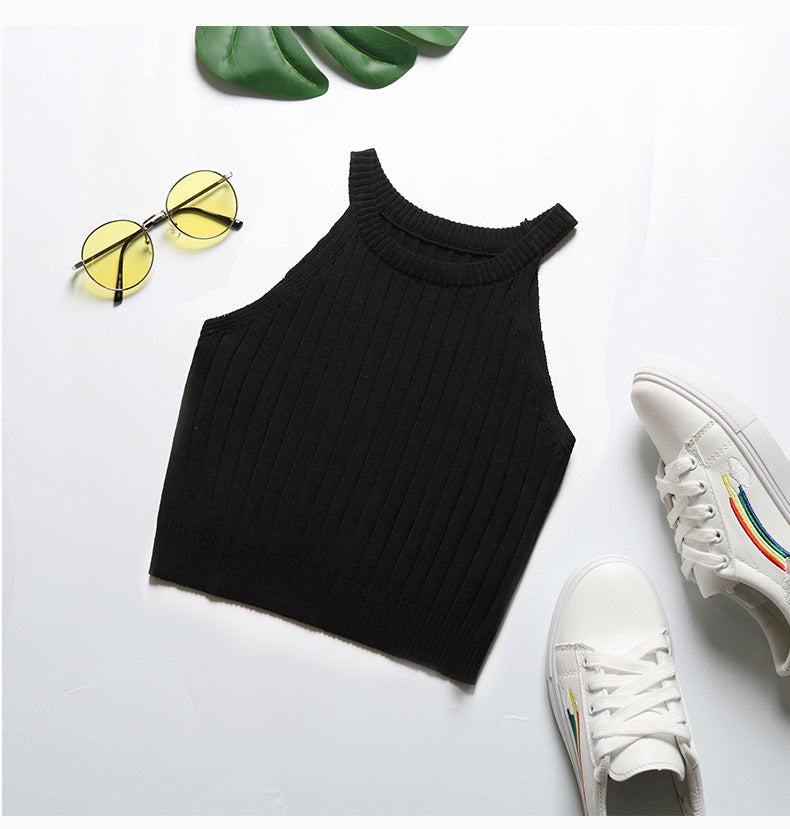 Black ribbed halter crop top flatlay with yellow-tinted sunglasses and rainbow accent sneakers