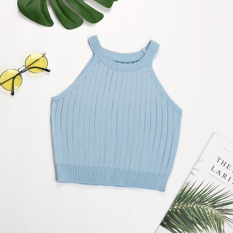 Sky blue ribbed halter crop top flatlay with monstera leaf and minimal styling
