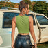 Back view of woman in two-tone tank top, leather shorts with heart chain belt, and star hair accessories
