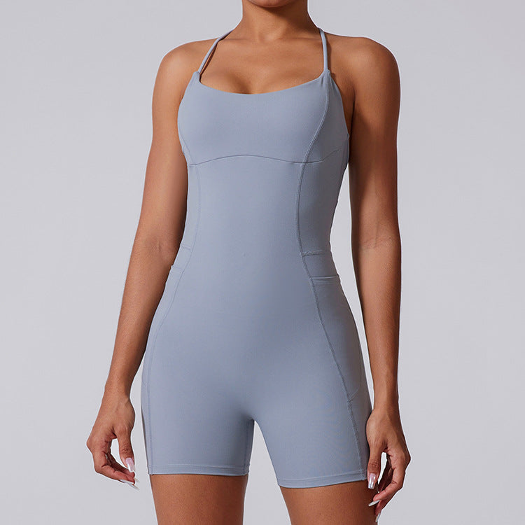 A model wearing a powder blue form-fitting bodysuit with spaghetti straps and built-in shorts against a light gray background