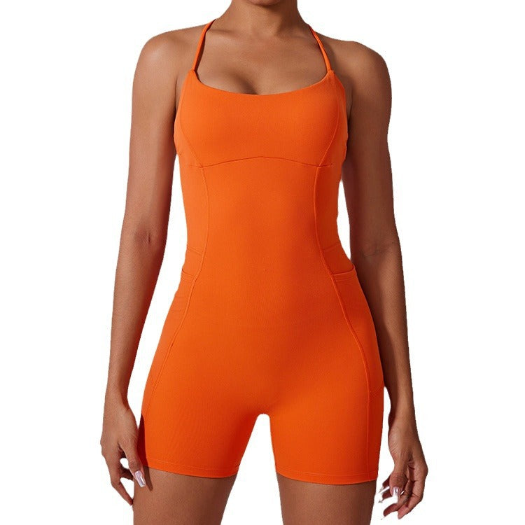 A model wearing bright orange form-fitting bodysuit with scoop neckline and compression shorts against light background