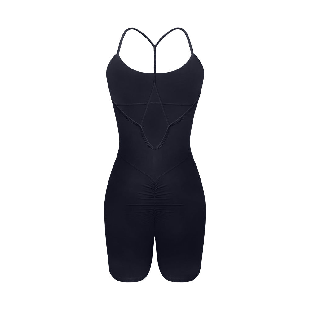 Back view of black performance bodysuit with T-strap design and ruched rear detail on white background
