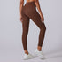 Rear view of brown high-waisted leggings with contoured seams and white platform sneakers against light background