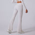 Rear view of white wide-leg yoga pants with high waistband and platform sneakers on light background