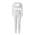 White V-neck workout set with long sleeve crop top and high-waisted leggings on white background