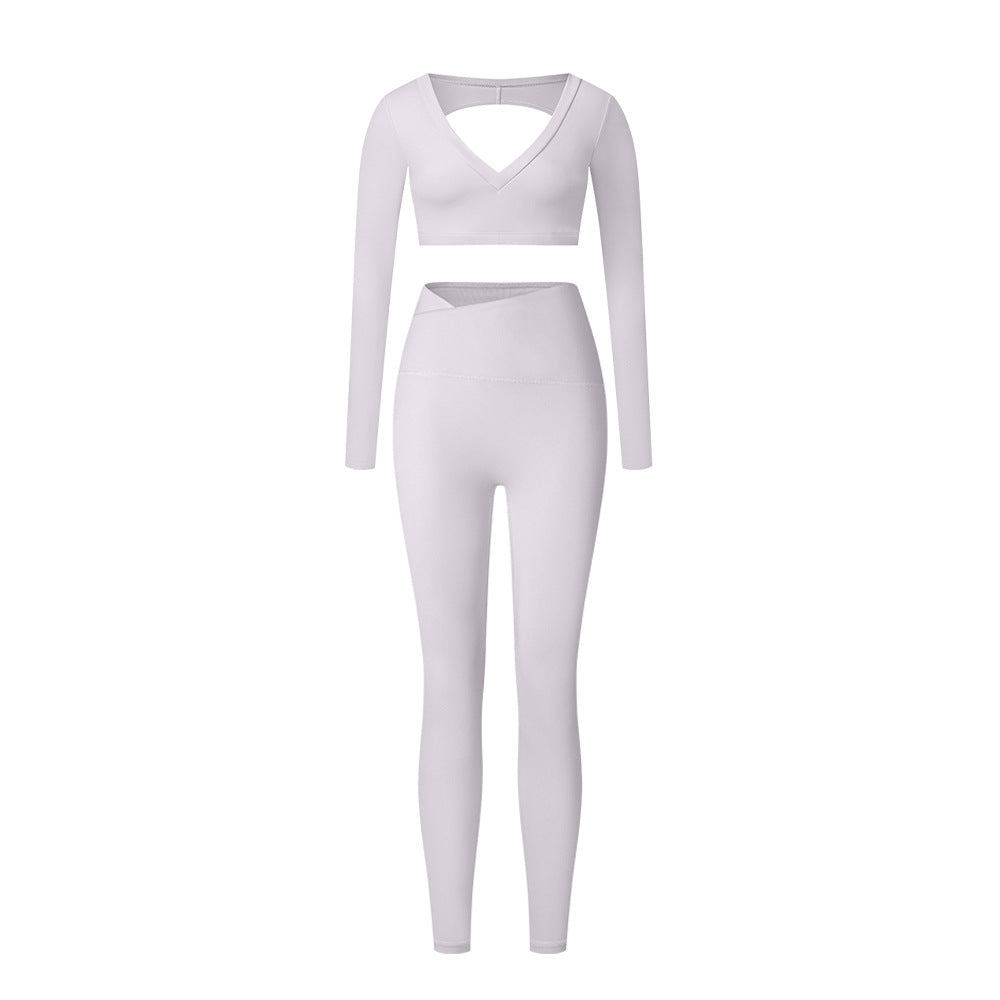 White V-neck workout set with long sleeve crop top and high-waisted leggings on white background