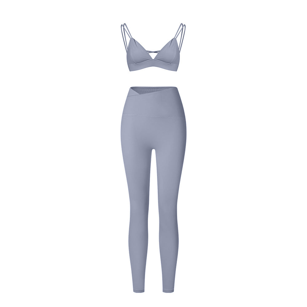 Powder blue strappy triangle bralette and high-waisted leggings set with asymmetrical waistband on white background