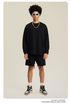Man in black sweatshirt and shorts set with white sunglasses, chain necklace and sneakers