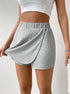 Close-up of grey jersey skort showing split-front overlay detail