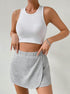 White crop tank top and grey jersey skort with built-in shorts, styled with silver accessories