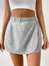 Close-up of grey jersey mini skort showing seamless waistband and overlay design