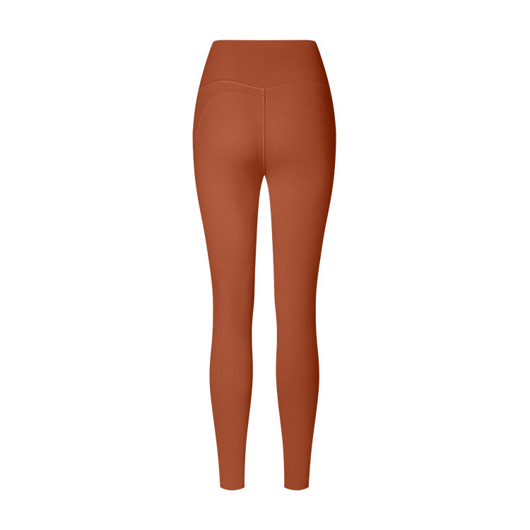 Terracotta high-waisted athletic leggings with curved back seams, photographed from behind against a white background