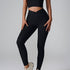 A model wearing black ribbed leggings with V-shaped waistband and matching crop top against gray backdrop