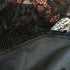 Close-up detail of black lace fabric showing intricate floral pattern and mesh texture