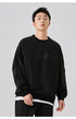 Male model wearing a black "NoProblem" oversized sweatshirt layered over a white shirt, creating a stylish contrast