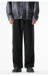 Black wide-leg drawstring pants displayed on a model wearing a gray leather jacket and black sneakers