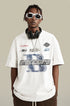 A model wearing white oversized t-shirt with street graphics, white-framed sunglasses and black headphones around neck against neutral backdrop