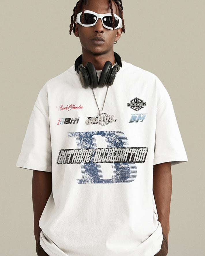 A model wearing white oversized t-shirt with street graphics, white-framed sunglasses and black headphones around neck against neutral backdrop