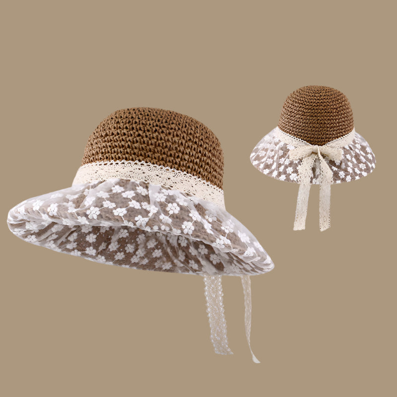 A brown woven sun hat with an elegant lace-trimmed brim and a ribbon bow at the back, emphasizing the intricate craftsmanship.