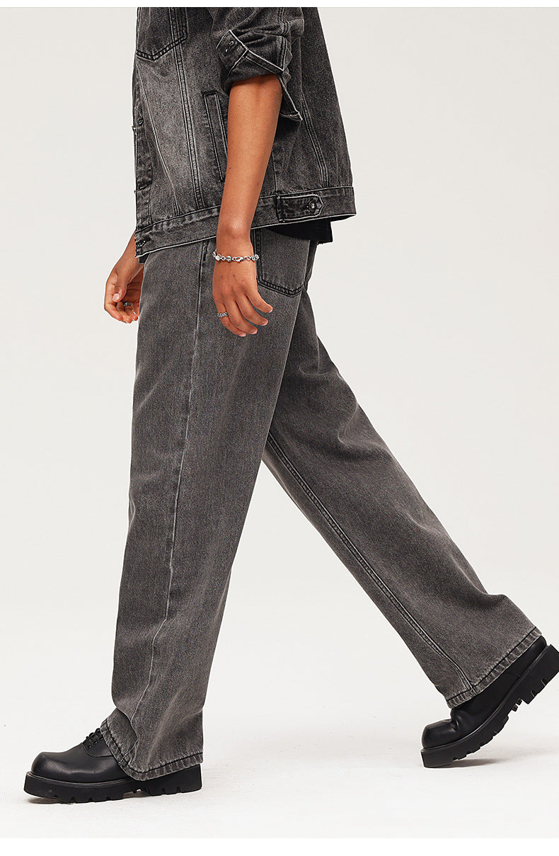 Walking pose highlighting wide-leg washed black jeans with chunky boots, demonstrating movement and fit