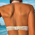 A woman's back view showing a white lace bralette with hook closure and scalloped lace trim