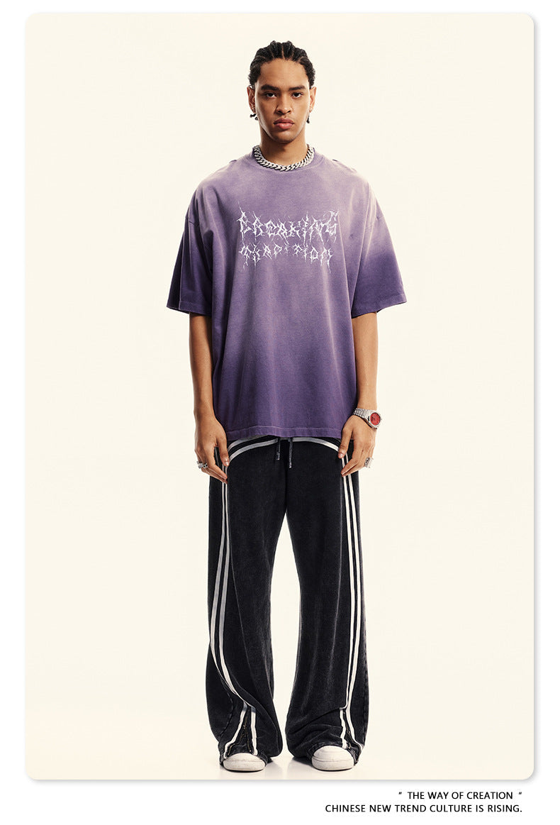 Purple gradient Breaking Tradition t-shirt paired with striped track pants, streetwear styling