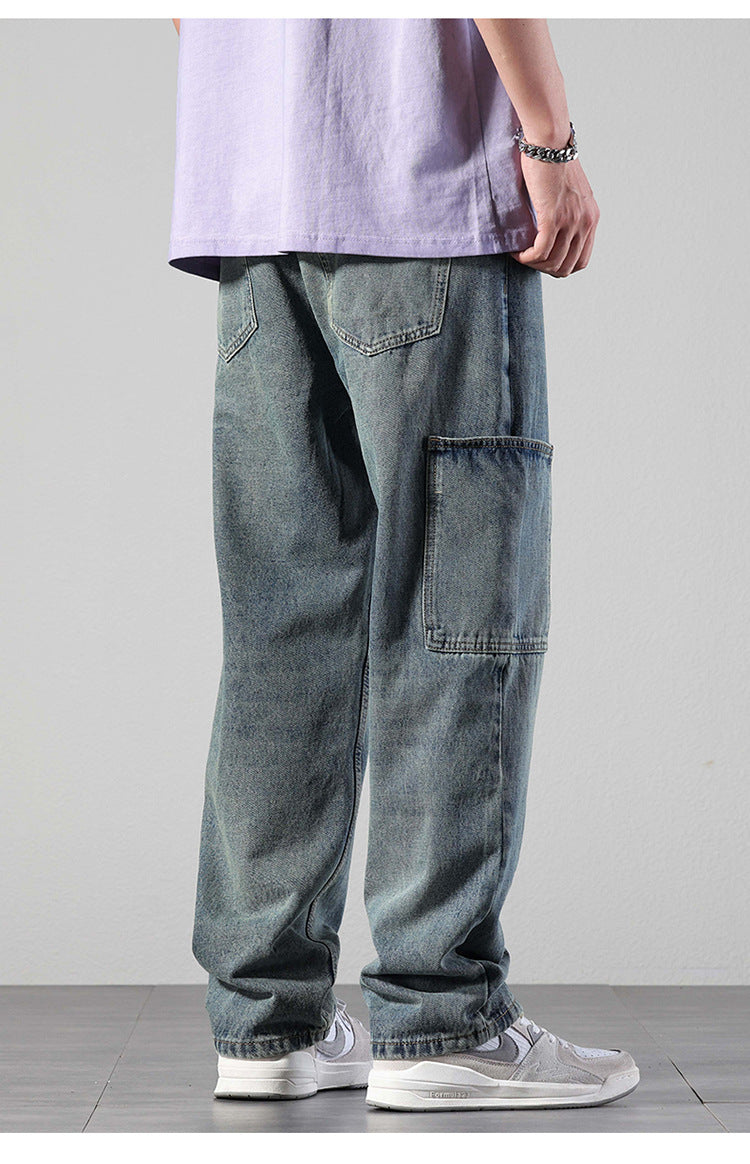 Rear view of model in washed denim cargo pants showing back pocket detail, paired with lavender tee and silver chain bracelet