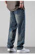 A person wearing relaxed fit washed denim jeans with silver chain bracelet and oversized gray t-shirt, viewed from back showing loose silhouette