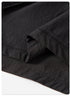 Close-up of black fabric hem detail with stitching against white background