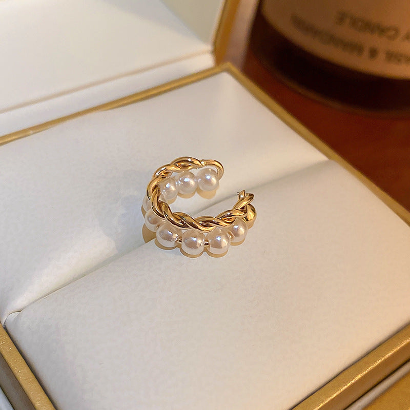Gold twisted ear cuff with pearl accents displayed in white jewelry box with gold trim