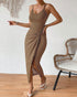 Woman walking in tan ribbed knit midi dress with high slit and side knot detail.